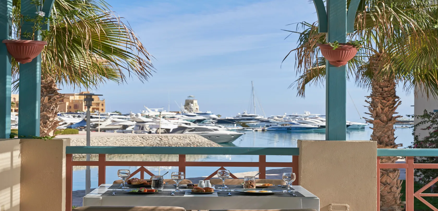 Food being served with a view overlooking the marina filled with yachts.