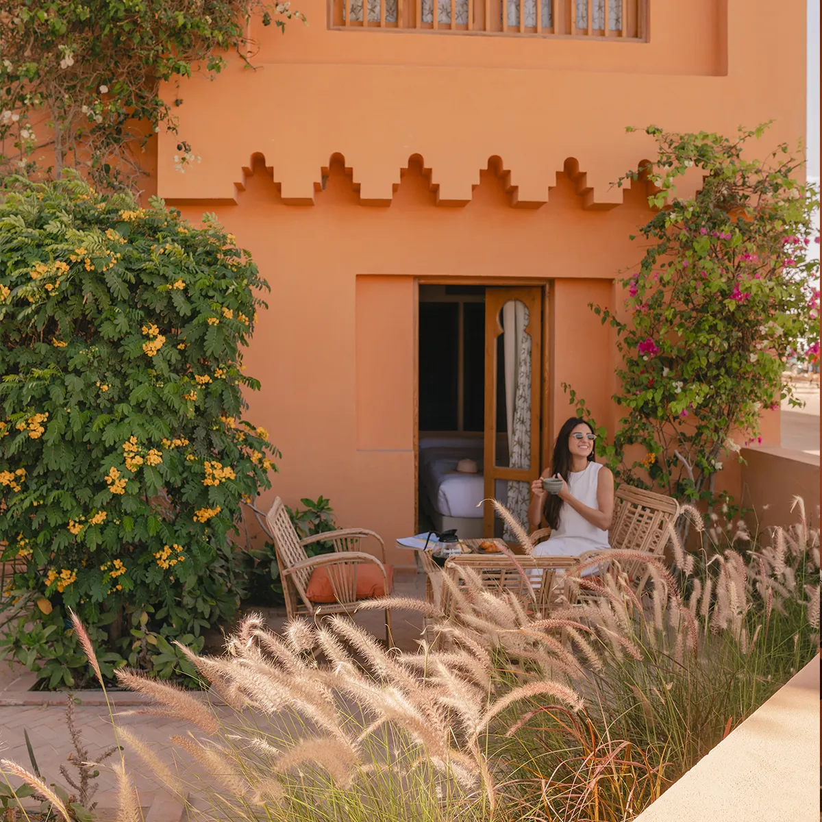 Woman enjoying beverage in her room terrace.