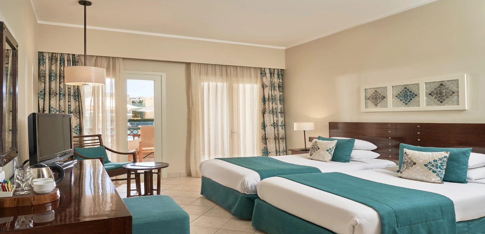 A twin room at Mosaique Hotel, featuring modern amenities and comfortable furnishings.