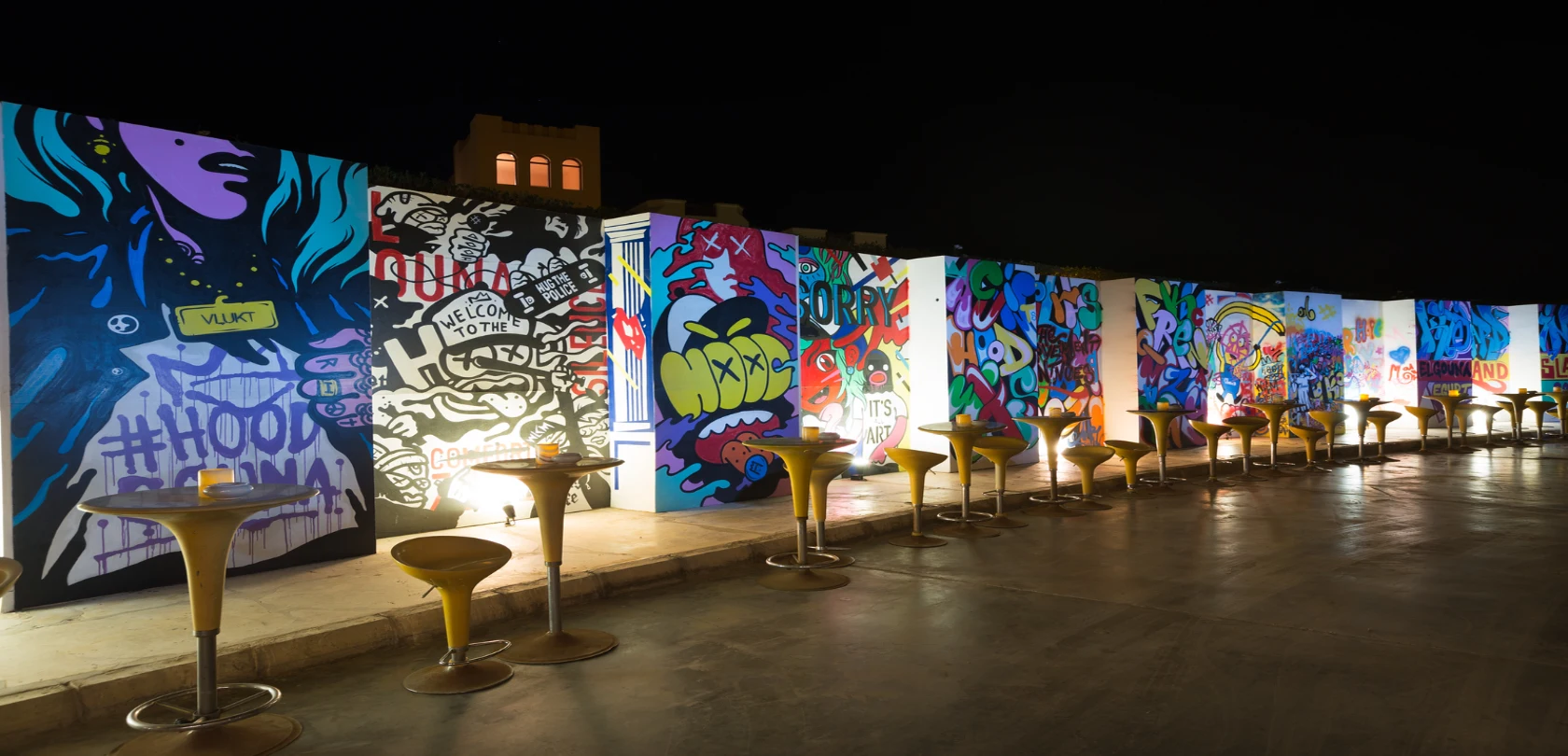 A graffiti wall adorned with colorful artwork, complemented by stylish chairs.